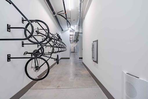 A hallway with bicycles hanging on the wall.