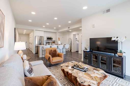 A modern living room with a stone coffee table and a flat screen TV.