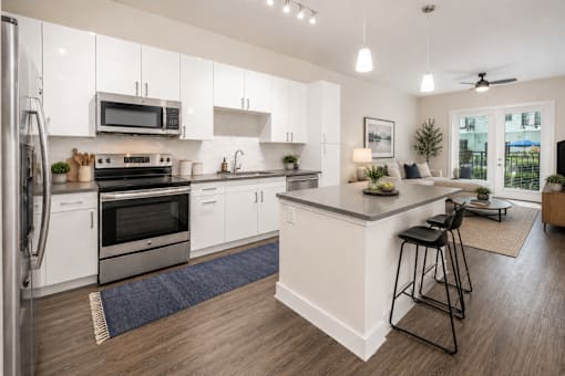 A modern kitchen with white cabinets and a large island.