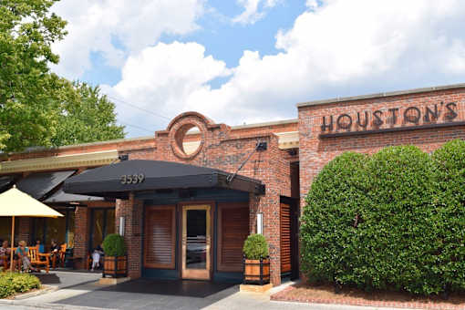 A restaurant named Houston's has a black awning and a brick exterior.