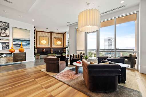 A living room with a large window and a view of the city.