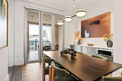 A modern dining room with a wooden table and chairs.