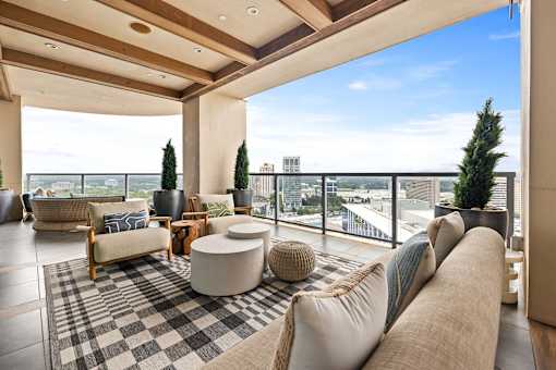 A living room with a large couch and a checkered rug.