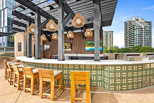 A bar with wooden chairs and a green patterned wall.