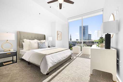 A bedroom with a large bed and a view of the city.