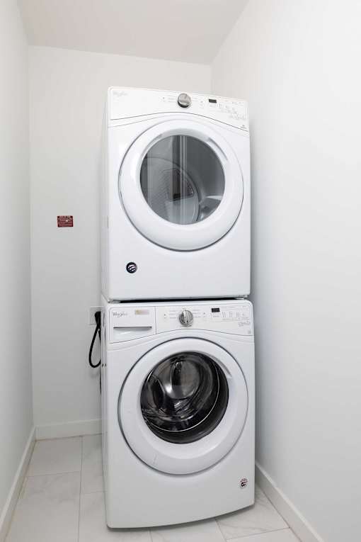A white washing machine and dryer in a small room.