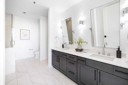 A bathroom with a white sink and a large mirror.