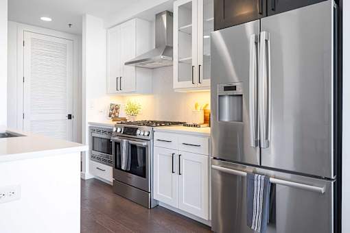 A modern kitchen with stainless steel appliances and white cabinets.