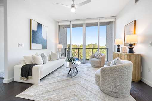 A living room with a white couch, a grey armchair, and a coffee table.