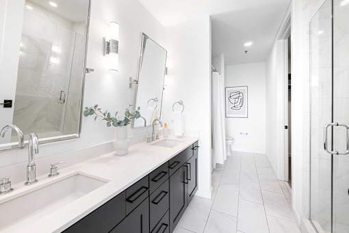 A bathroom with a white sink and a large mirror.