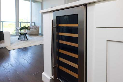 A modern kitchen with a white cabinet and a black and gold fridge.