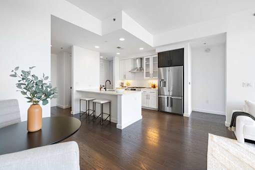 A modern kitchen with a black table and white cabinets.