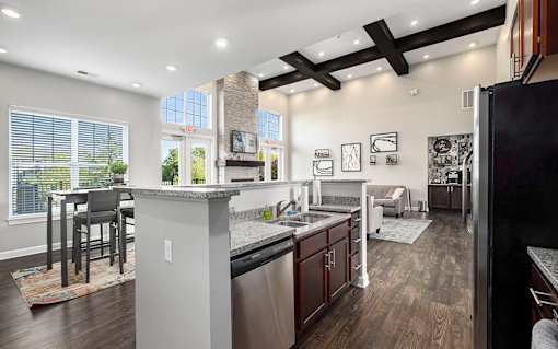A modern kitchen with dark wood floors and stainless steel appliances.