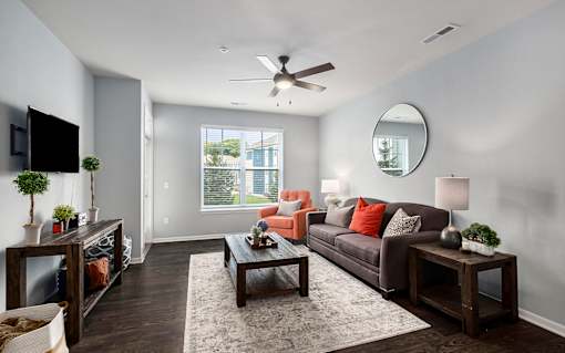 A living room with a brown couch, a wooden coffee table, and a flat screen TV.