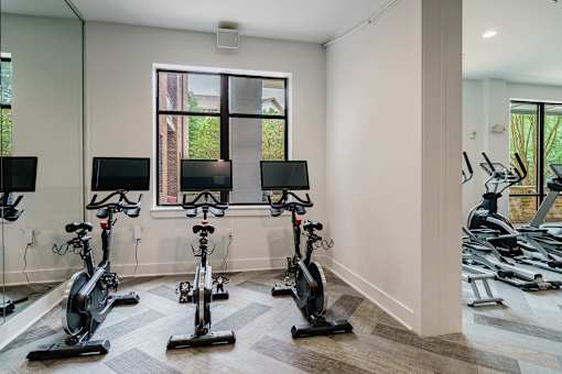 A room with a row of stationary bikes.