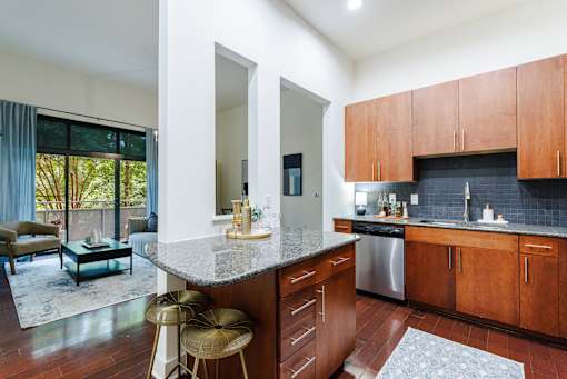 A kitchen with wooden cabinets and a marble countertop.