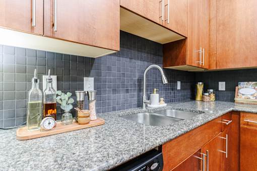 A kitchen with a granite countertop and wooden cabinets.