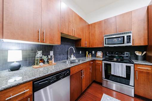 A kitchen with wooden cabinets and a granite counter top.