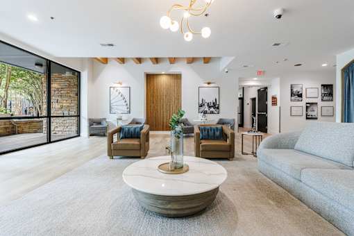 A living room with a large rug and a coffee table in the center.