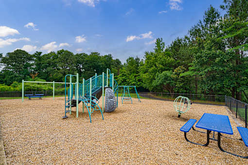 A playground with a blue table and a swing set.