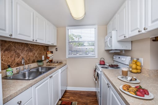 a kitchen with white cabinets and a sink