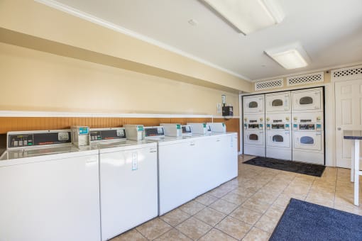 a laundry room with washers and dryers and a counter with washing machines