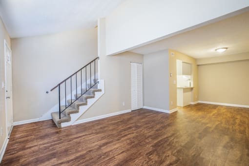 the living room and dining room of a renovated house with wood flooring