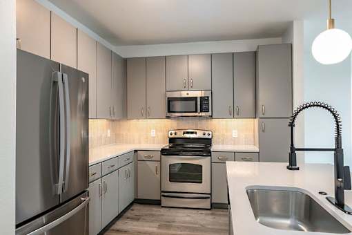 A modern kitchen with stainless steel appliances and a central island.