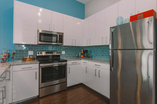 a kitchen with stainless steel appliances and white cabinets