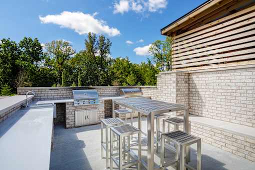 A patio with a table and chairs is surrounded by a brick wall.
