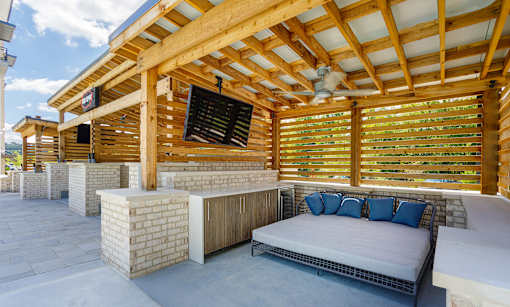 A wooden structure with a bed and a fan.