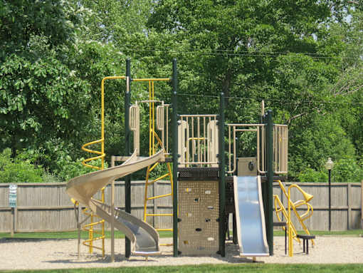 A playground with a yellow and grey slide.