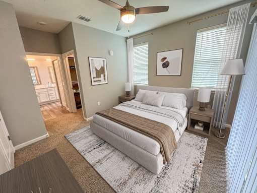 A bedroom with a large bed and a ceiling fan.