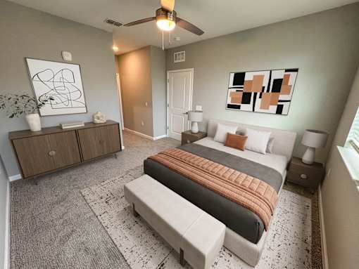 A bedroom with a bed, a bench, and a ceiling fan.