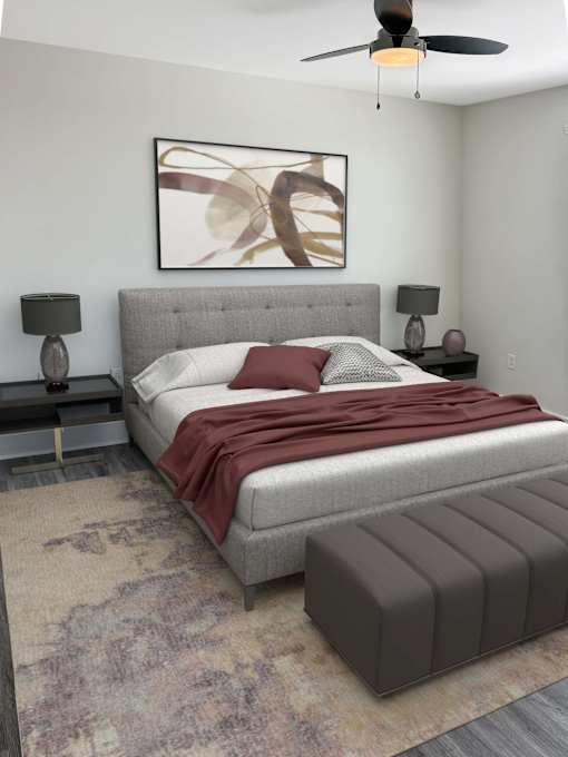 A bedroom with a large bed and a ceiling fan.