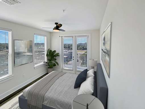 A bedroom with a large bed and a ceiling fan.