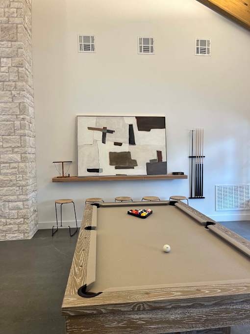 a pool table in a room with a painting on the wall