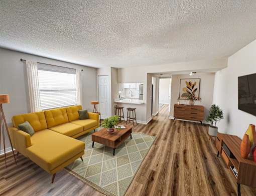 A living room with a yellow sofa and a wooden floor.
