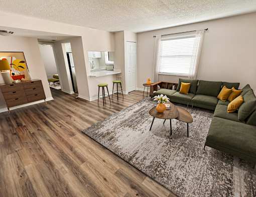 A living room with a green couch and a wooden floor.