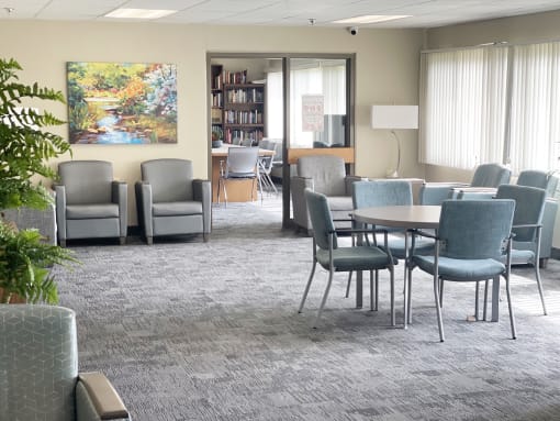 a room with a table and chairs and a painting on the wall
