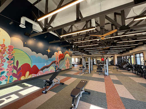 A gym with a colorful mural on the wall.
