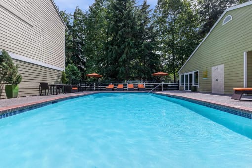 a large swimming pool with umbrellas and chairs around it