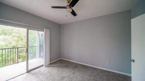 a living room with a ceiling fan and a sliding glass door
