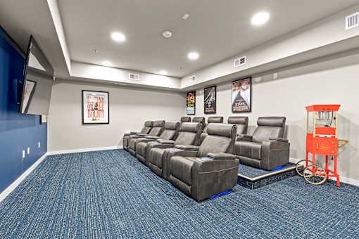 A movie theater with a row of seats and a red cart.