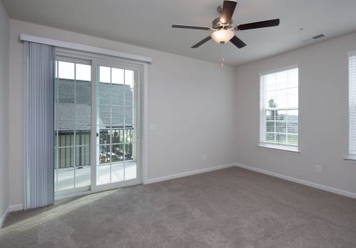 an empty bedroom with a ceiling fan