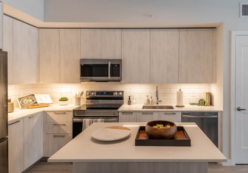 a kitchen with white cabinets and stainless steel appliances at Leena Plantation, Plantation, FL