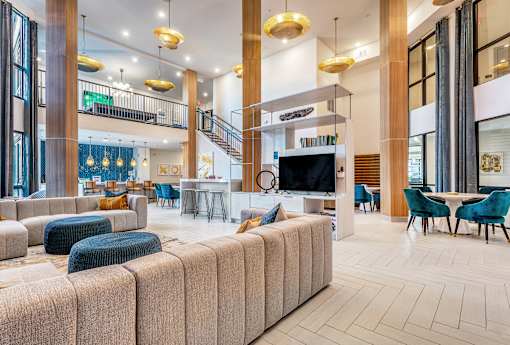 A large, modern living room with a staircase and a television.