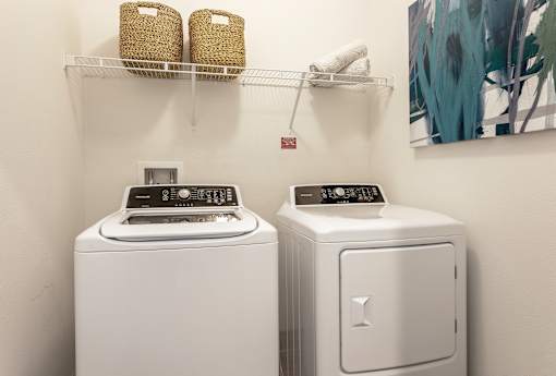 A white washing machine and dryer in a small laundry room.