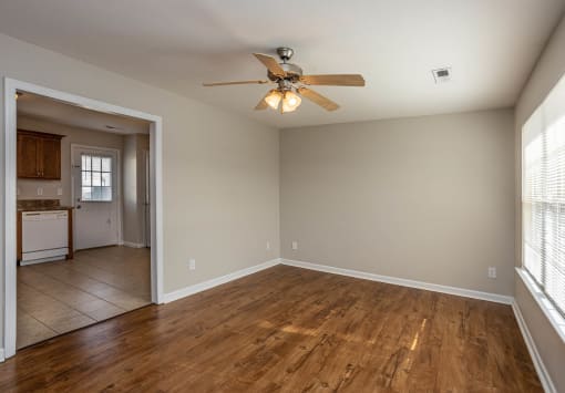a bedroom with a ceiling fan and a kitchen in the background