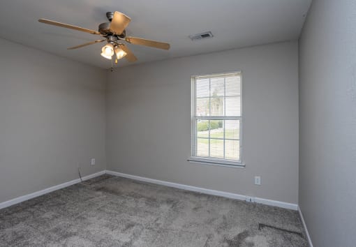a bedroom with a ceiling fan and a window